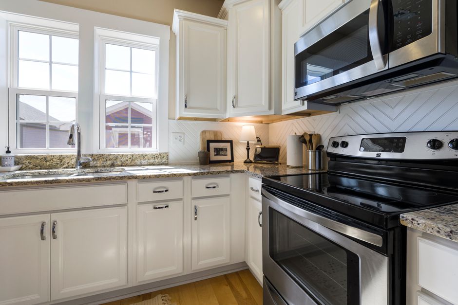 Freshly painted white kitchen cabinets with modern hardware in a bright kitchen