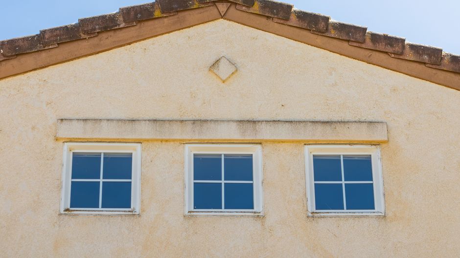 Stucco home exterior with fresh paint under clear sky